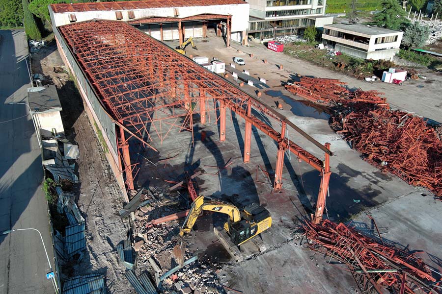 scheletro principale della fabbrica mentre viene demolito dal cingolato