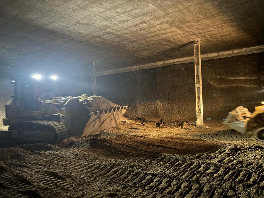 Mezzo cingolato che sposta terra in ambiente interrato
